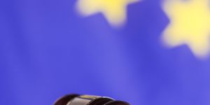 Oak gavel resting on soundblock on european union flag background